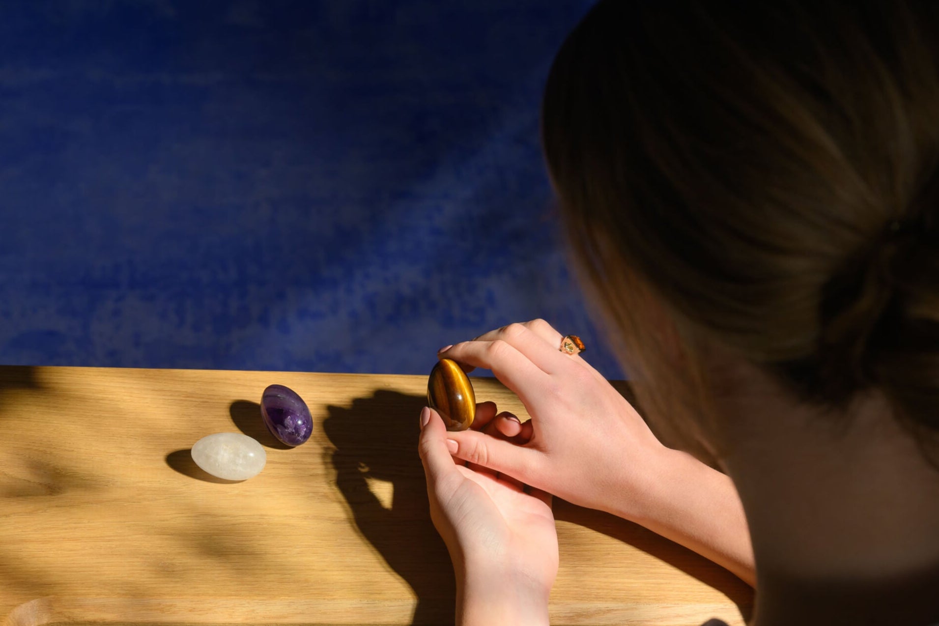 Model holding tiger's eye gemstone egg.