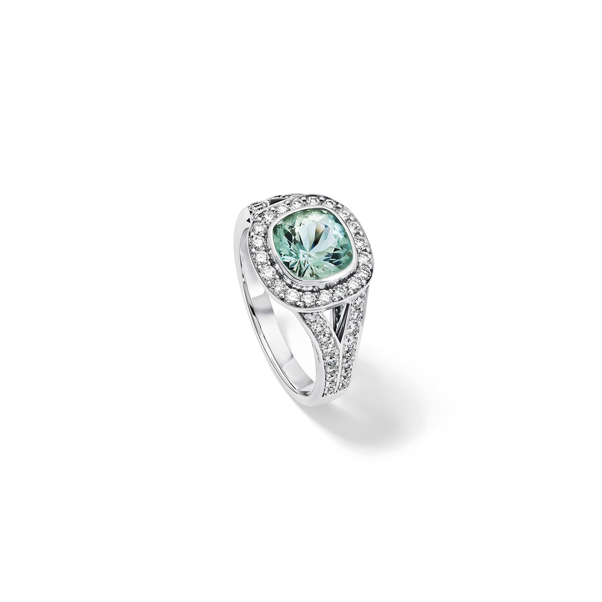 Handcrafted 18ct white gold engagement ring featuring a large, cushion-cut green aquamarine surrounded by a halo of small diamonds and smaller diamonds embedded along the band, March birthstone