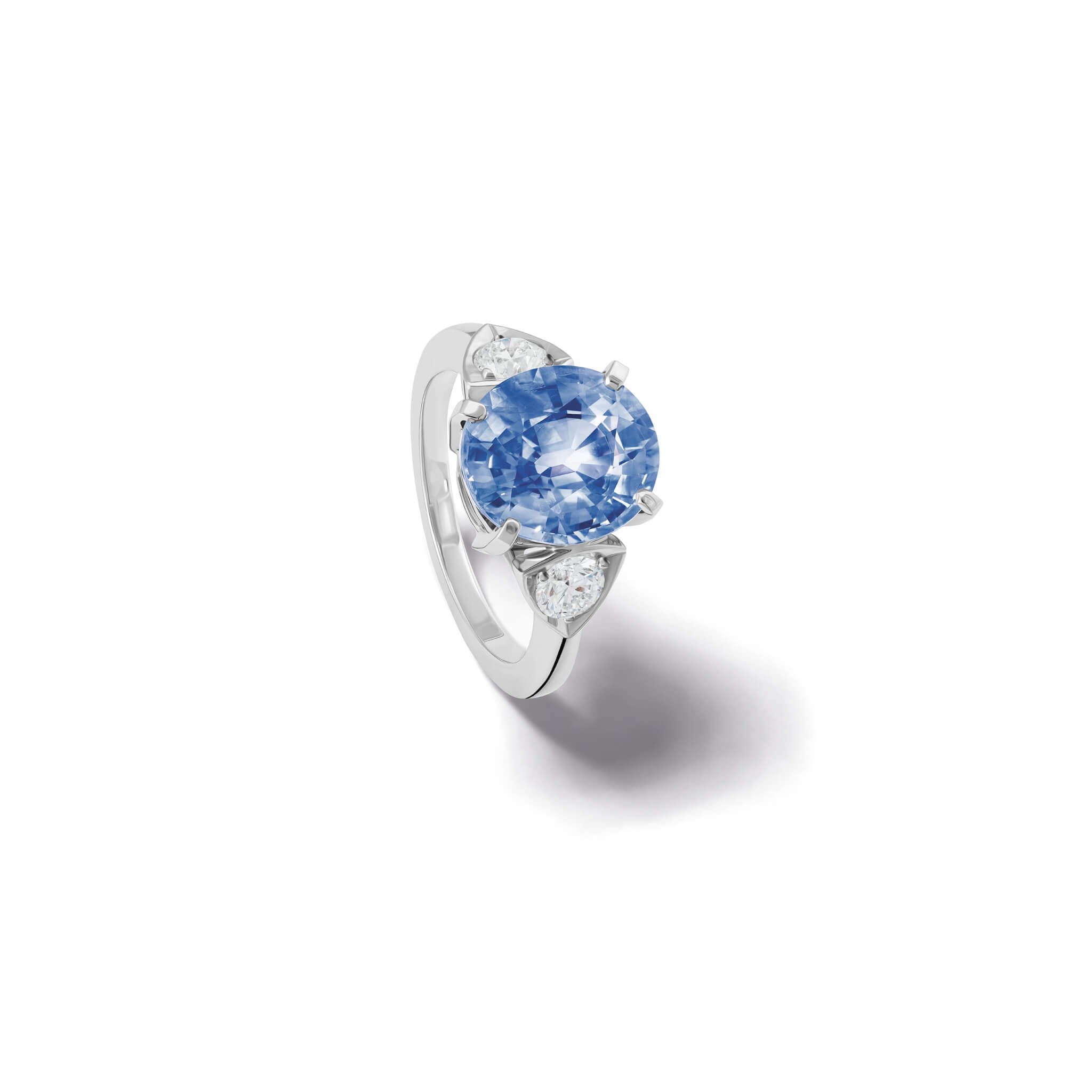 Handcrafted 18ct white gold engagement ring featuring a large central oval sapphire flanked by one smaller teardrop-shaped diamond on each side.