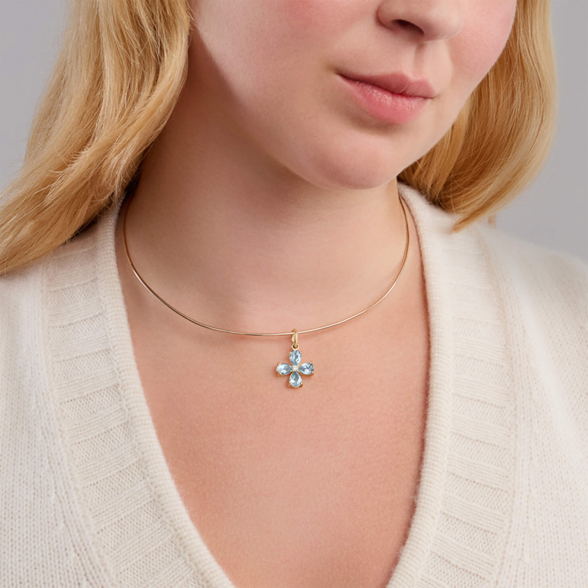 Handcrafted yellow gold four-leaf clover necklace pendant with blue topaz and diamond, birthstone of November.