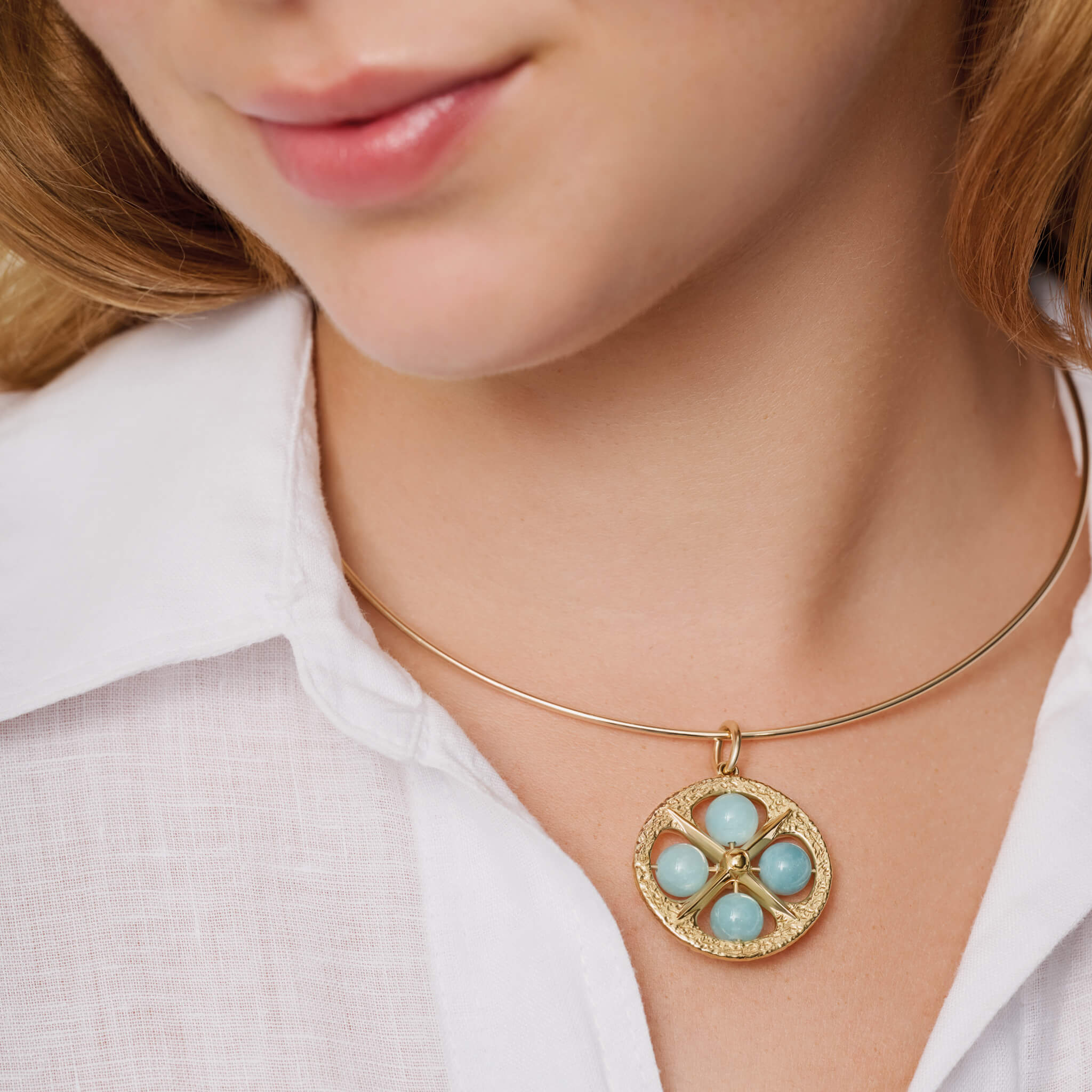 model wearing handcrafted pendant in yellow gold with aquamarine, march birthstone