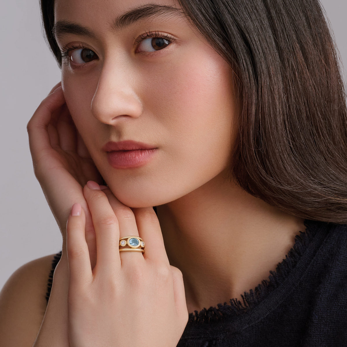 Model wears handcrafted 18ct yellow gold Aeneus ring with oval aquamarine and diamonds. March birthstone.
