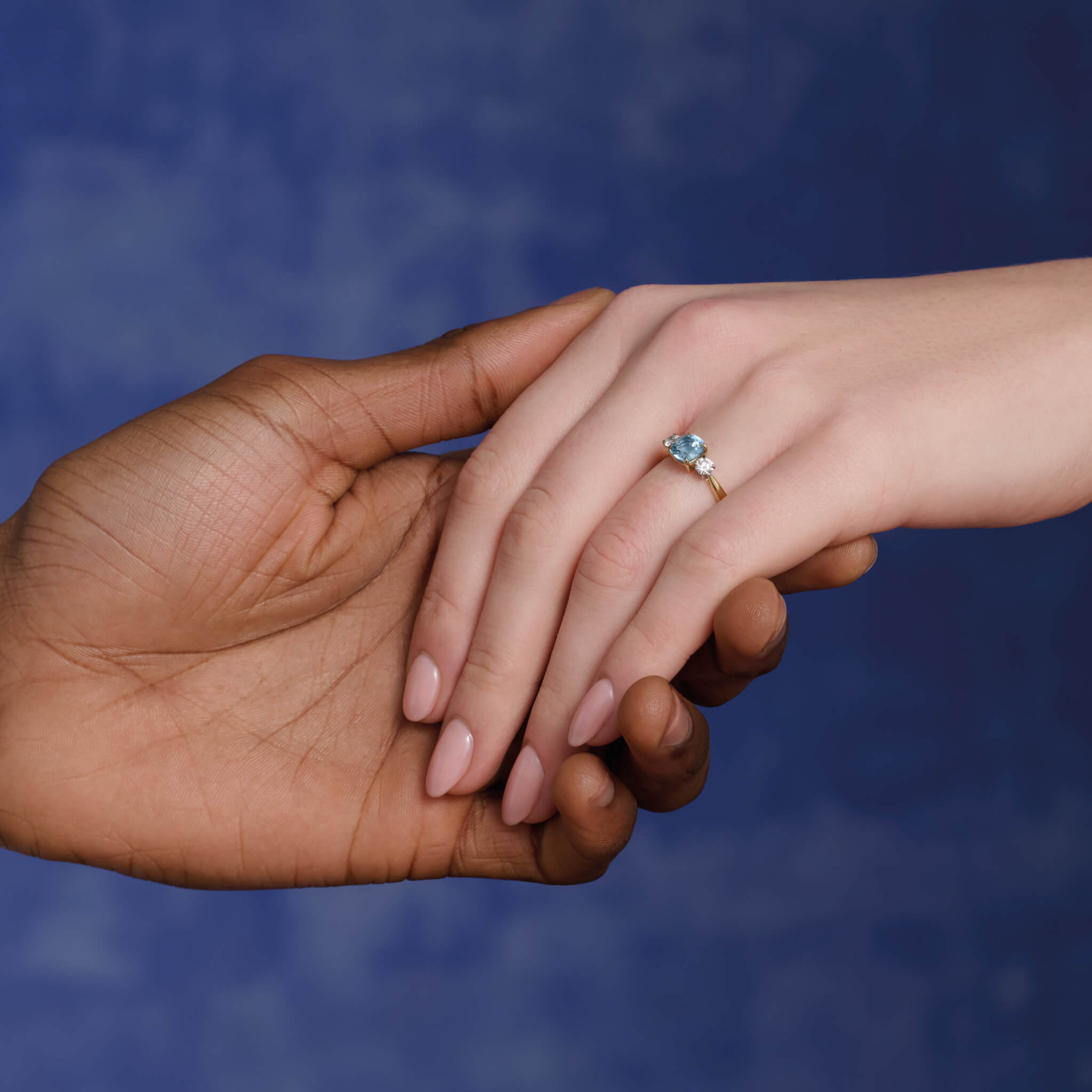 Model wears handcrafted Delilah engagement ring in 18ct yellow and white gold with aquamarine and diamond.