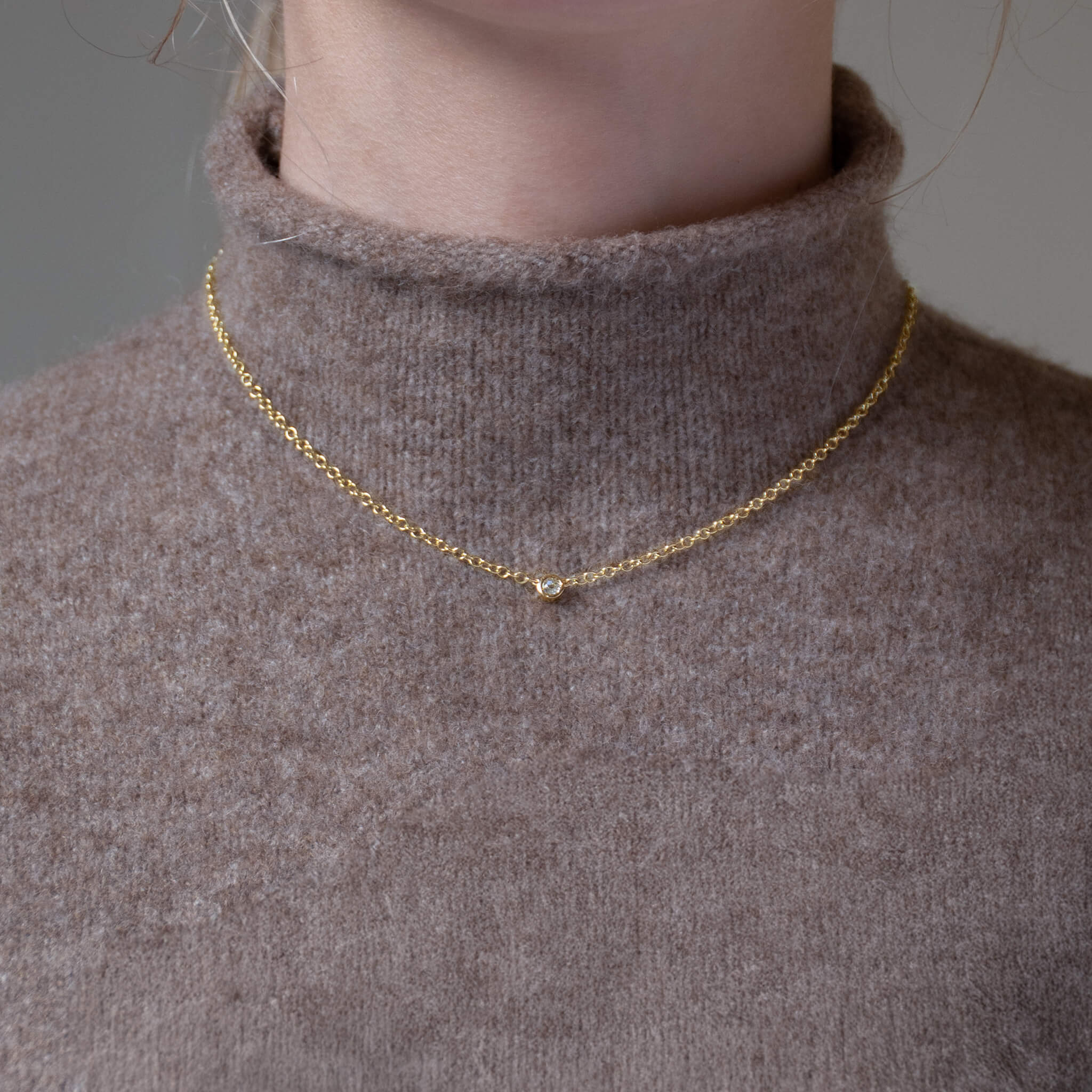 Handcrafted yellow gold necklace with a single medium diamond on an adjustable chain, april birthstone