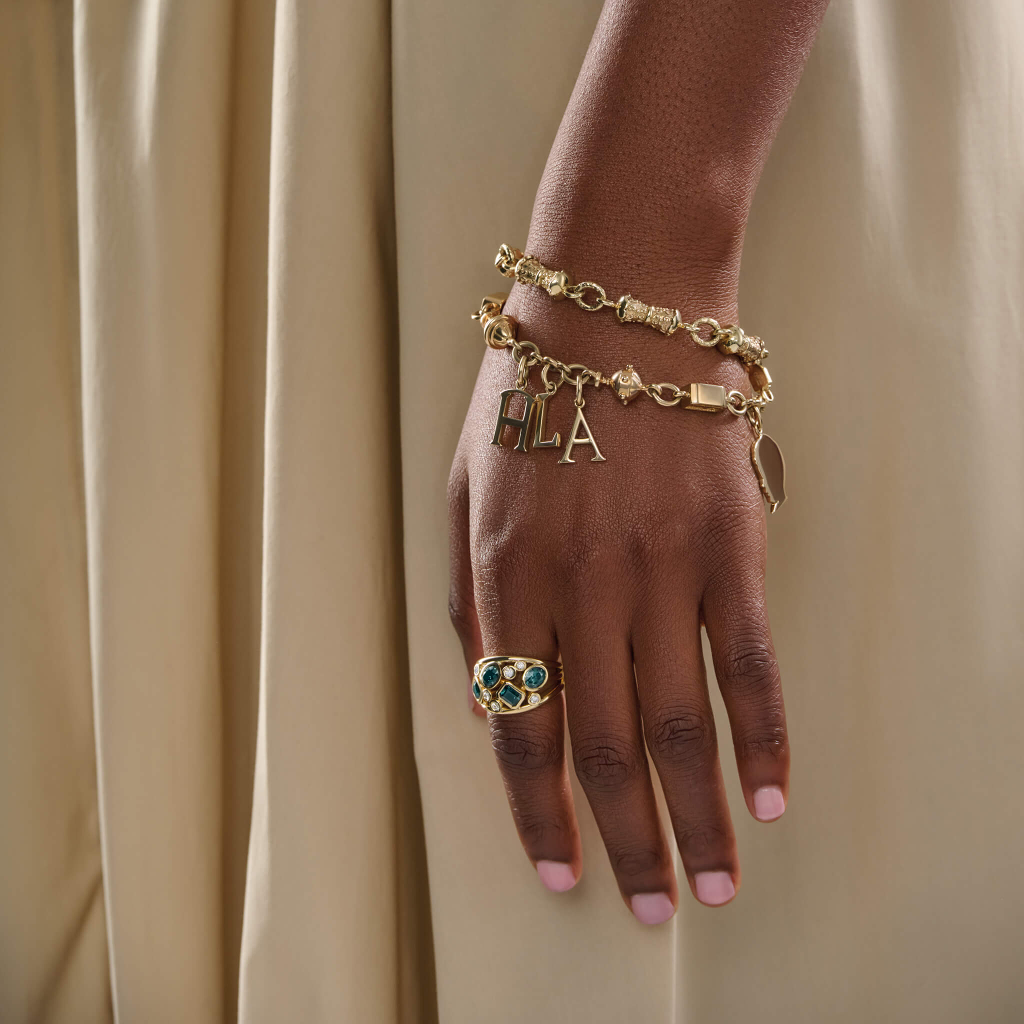 Model wears handcrafted yellow gold Epiphany bracelet perfect for adding charms and pendants.