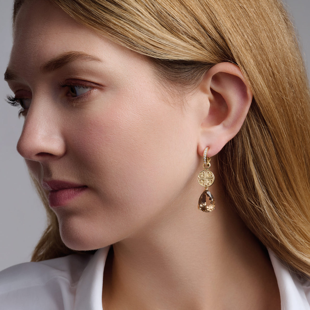 Model wears handcrafted 9ct yellow gold Luiza stud earring pendants with pale facetted smoky quartz, inspired by Rio de Janeiro, Brazil