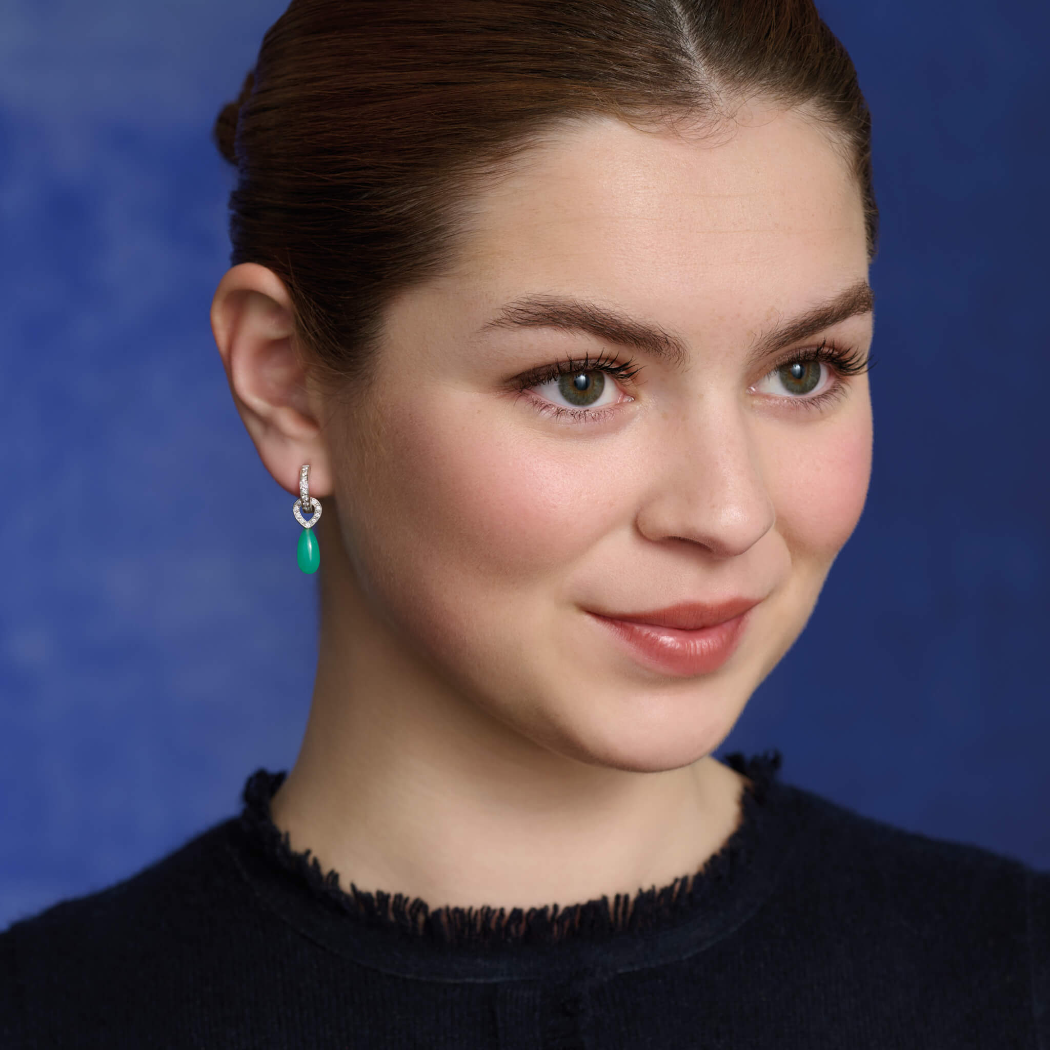 Model wears the Octavia earring drops in 18ct white gold, with smooth briolette apple green chrysoprase and diamond.