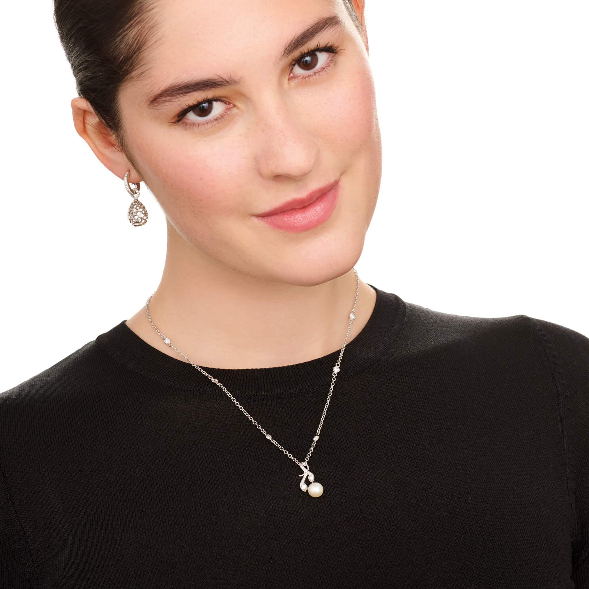 Model wears handcrafted white gold necklace pendant in the shape of a rosemary sprig with a pearl at the bottom.