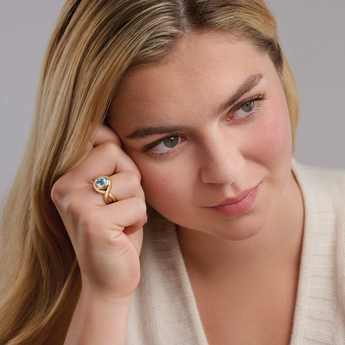 model wears handcrafted 9ct yellow gold Severine ring featuring curved shanks