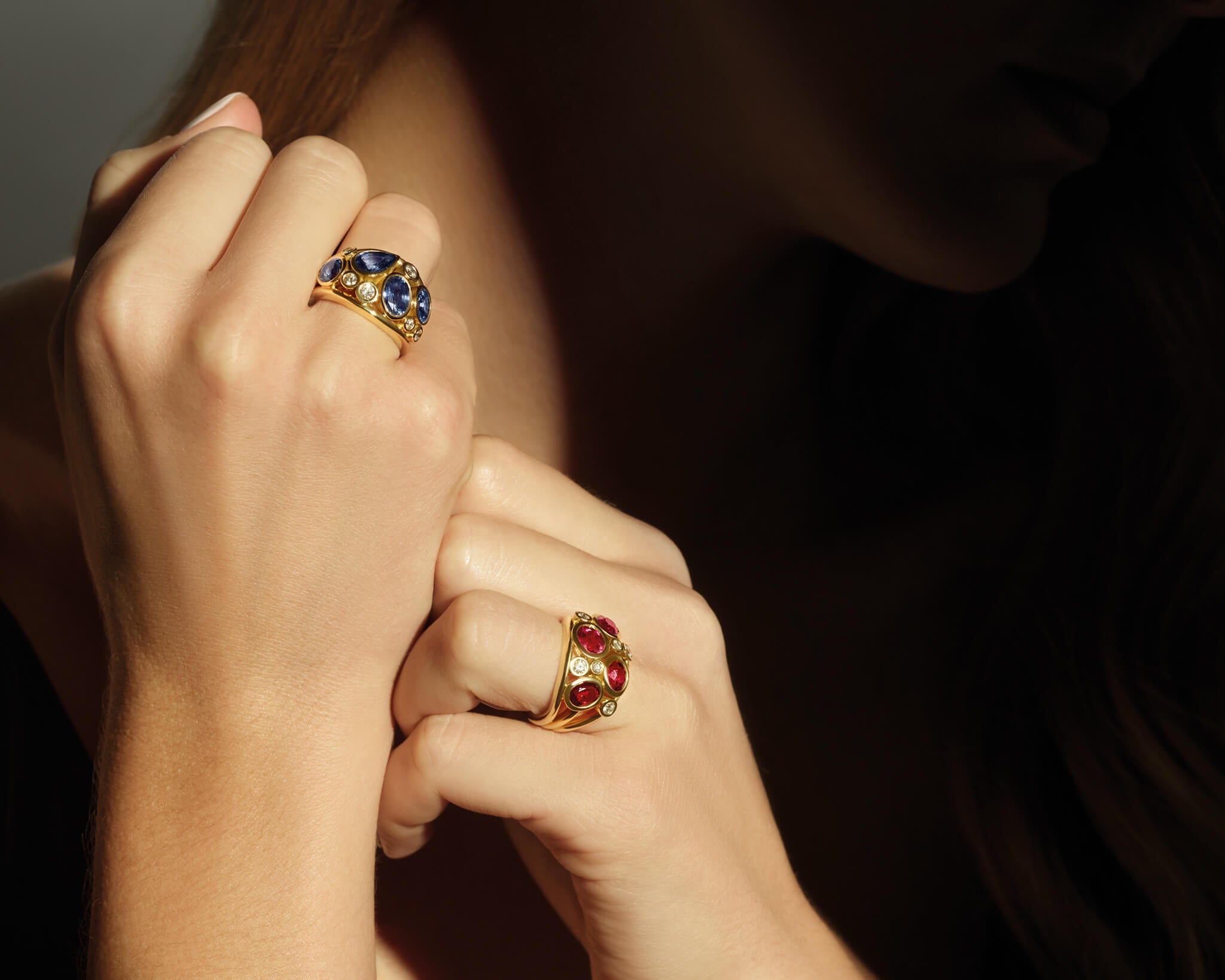 Model wears the Multi Aeneus ring in 18ct yellow gold with rubies and diamonds and the Multi Aeneus ring in 18ct yellow gold with blue sapphires and diamonds