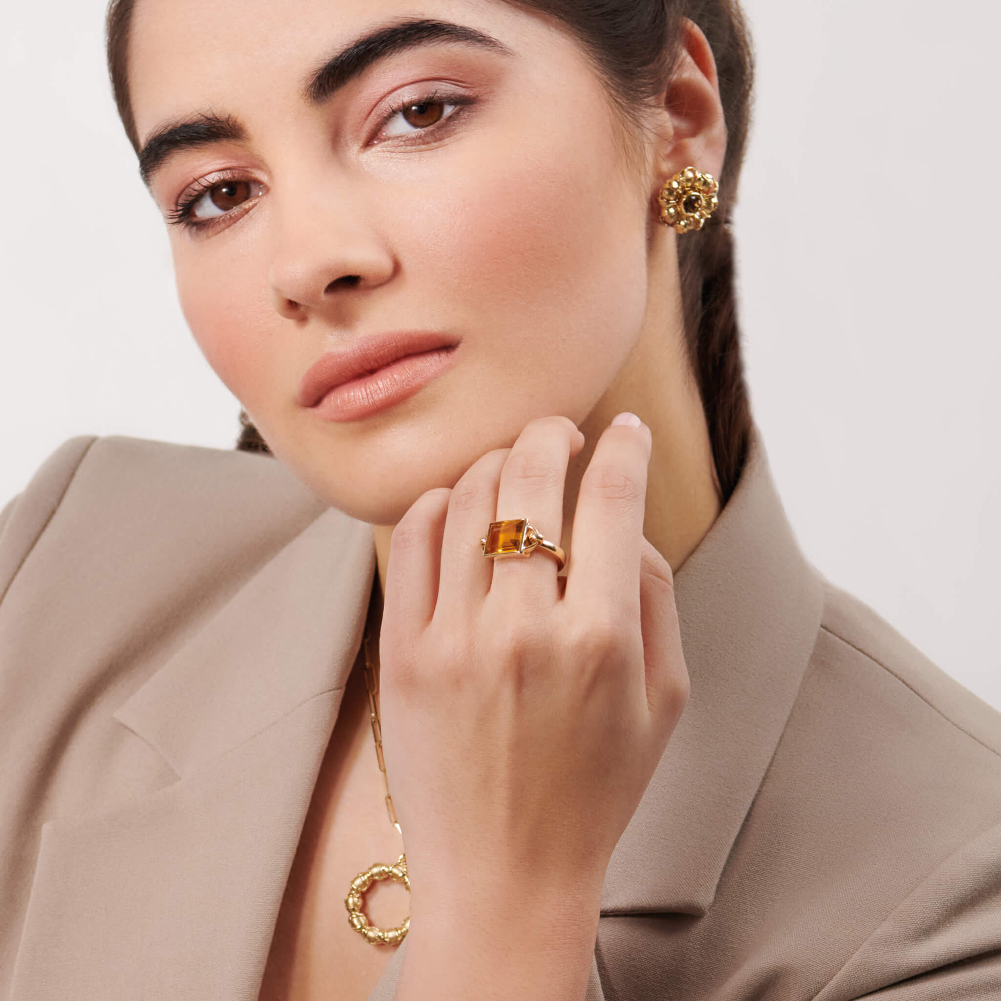 Model wears handcrafted yellow gold ring featuring a central baguette cut citrine, birthstone of November.