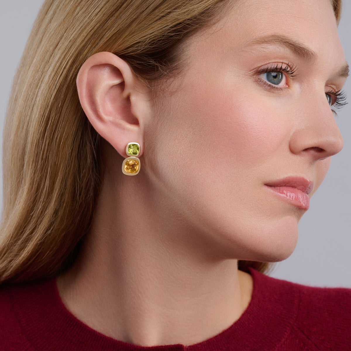 Model wears handcrafted Qin & Han earrings in 18ct yellow gold with peridot and citrine, birthstones of August and November