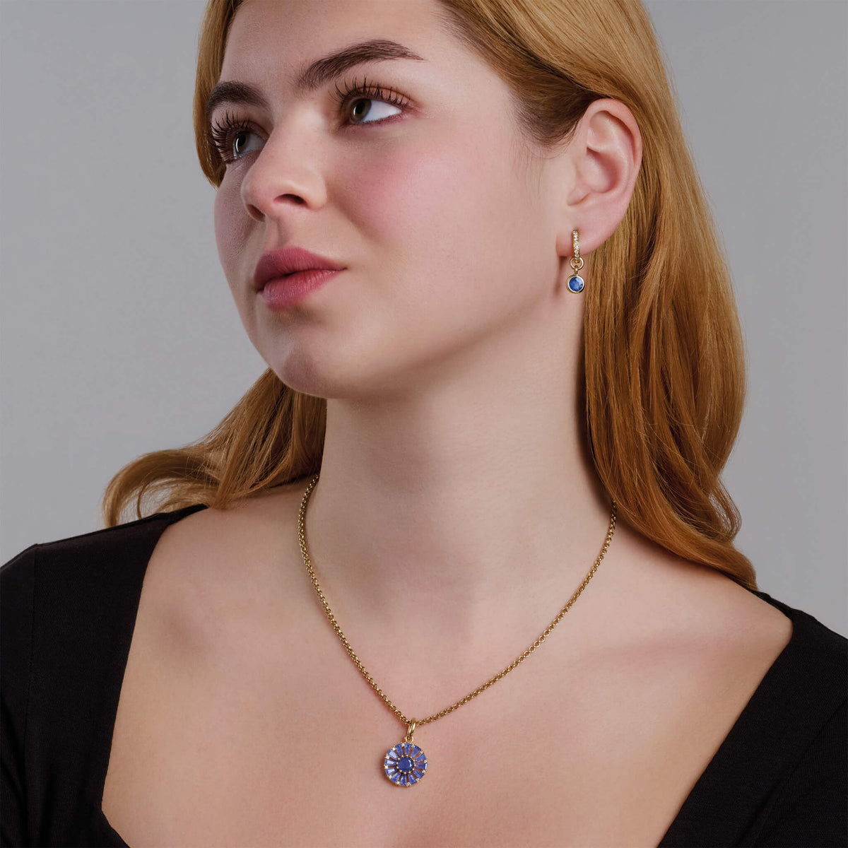 Model wears Roi Soleil small pendant with facetted baguette cut blue sapphire and diamond. The birthstone for September.