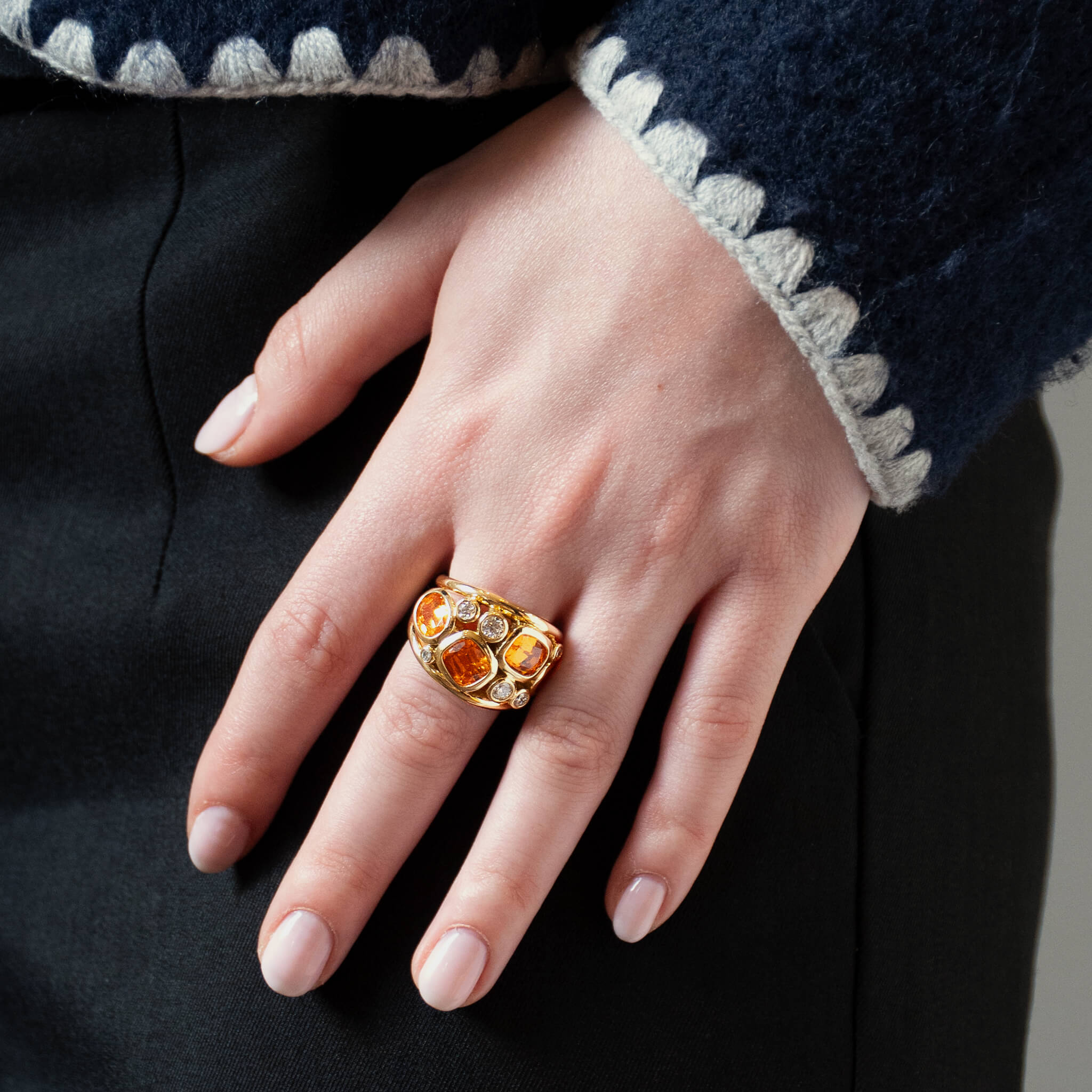 Handcrafted 18ct yellow gold ring featuring four mandarin garnets and smaller diamonds.