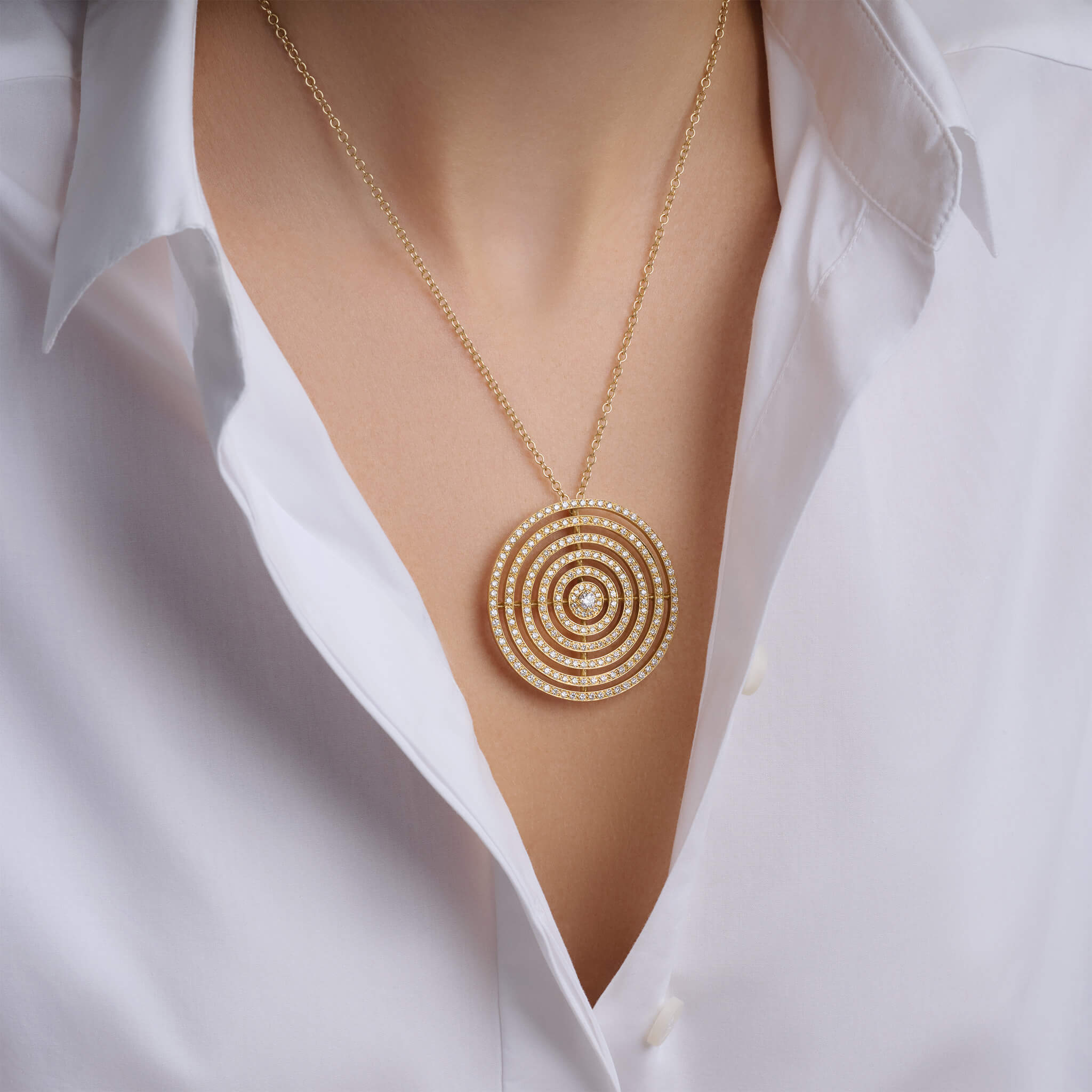 Model wearing a handcrafted 18ct yellow gold necklace pendant featuring five rows of circles with diamonds.