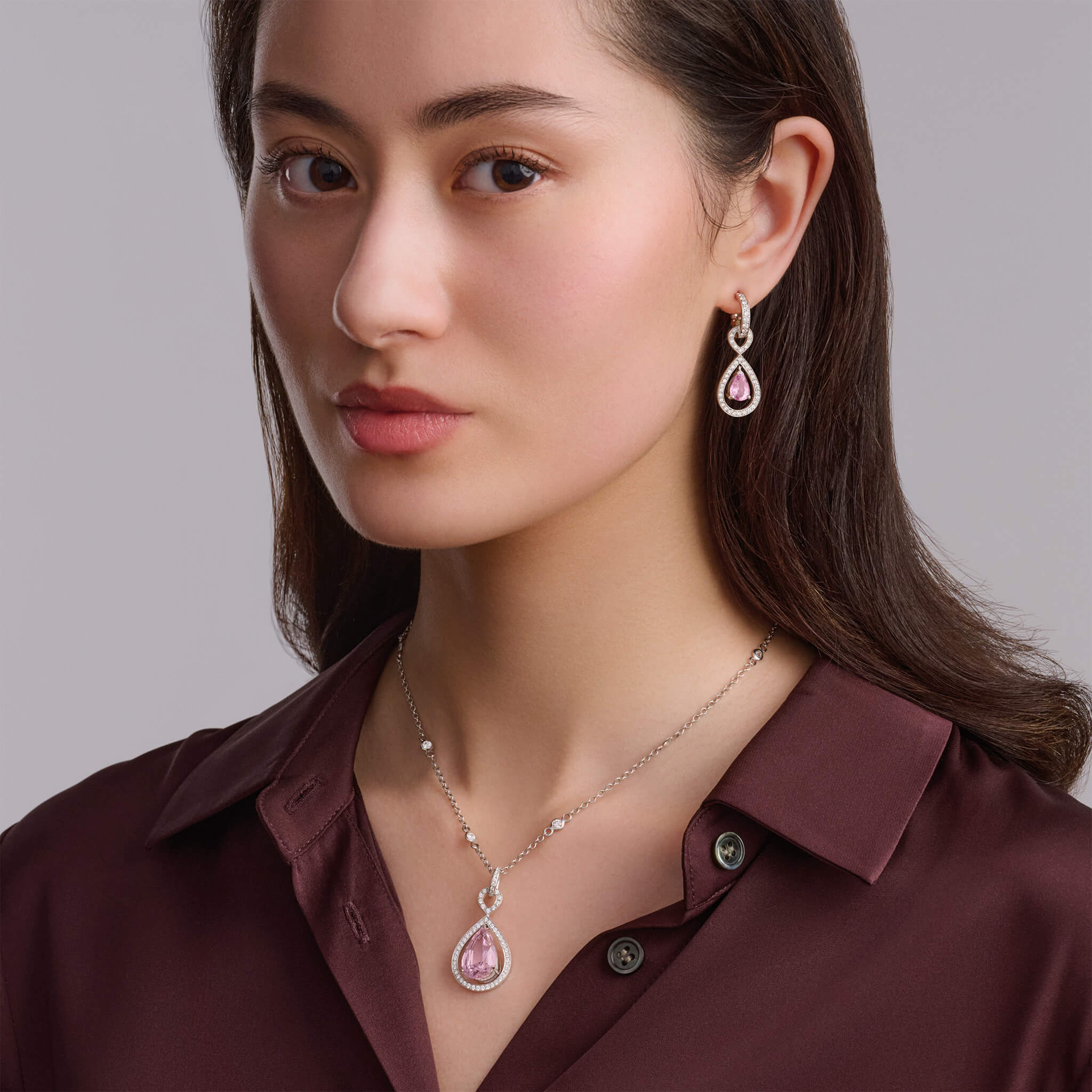Model wearing a handcrafted 18ct white gold necklace pendant featuring a central morganite surrounded by diamonds.