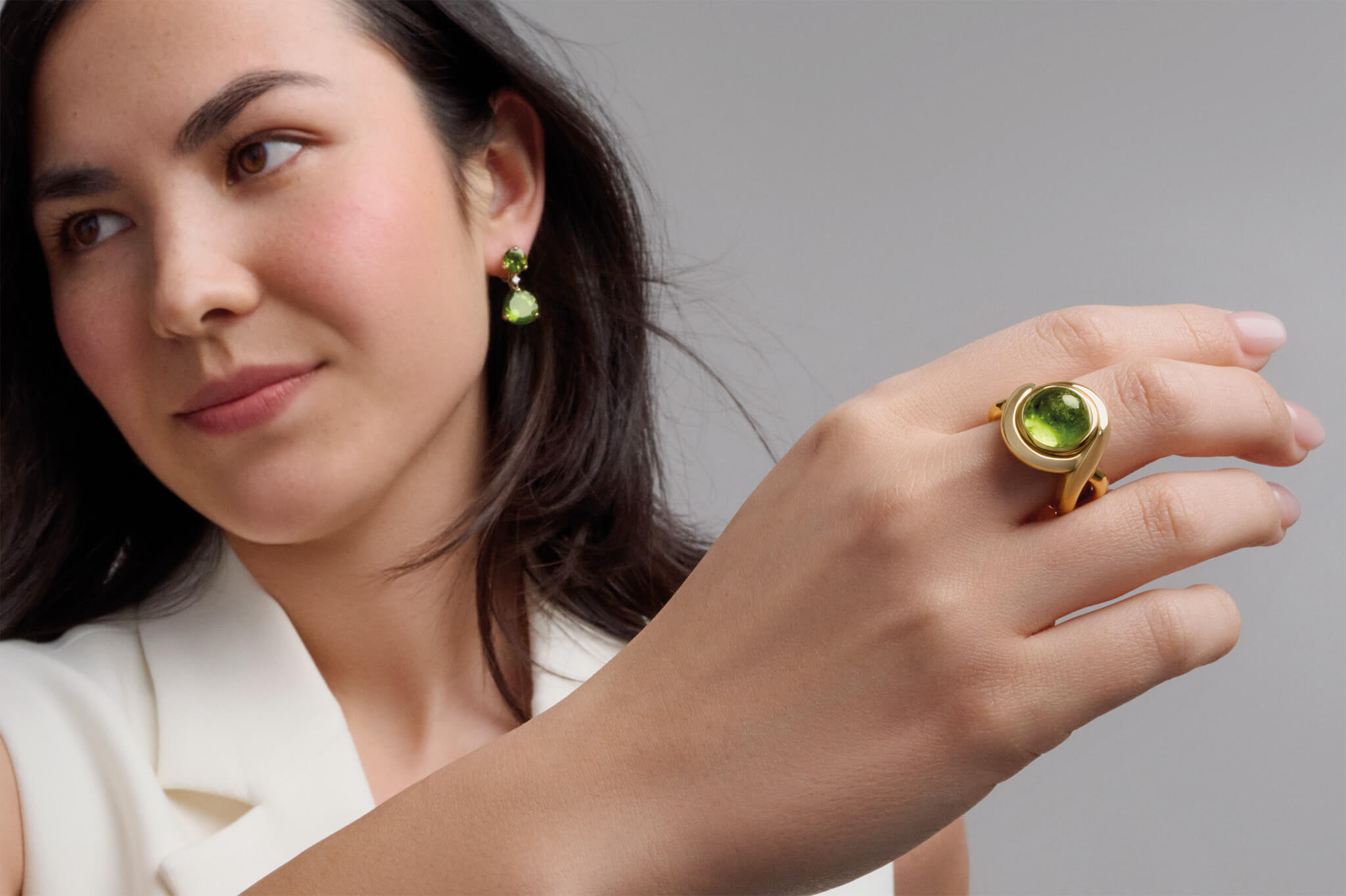 Model wearing peridot Severine ring and Riviere earring drops.