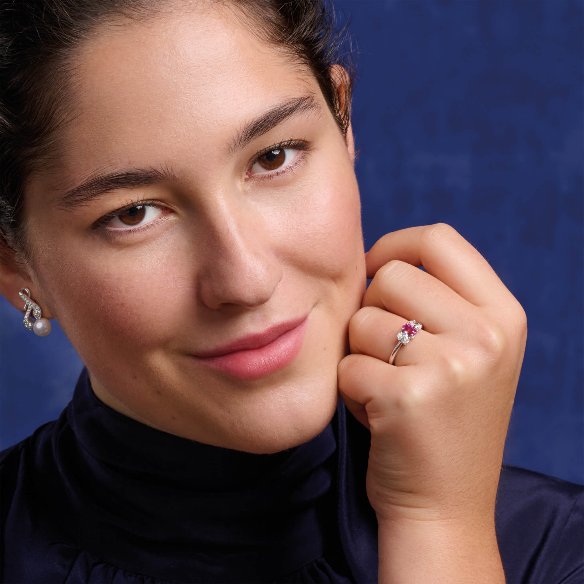 Model wears handcrafted 18ct white gold earrings with diamonds and a pearl drop in the shape of a sprig of rosemary.