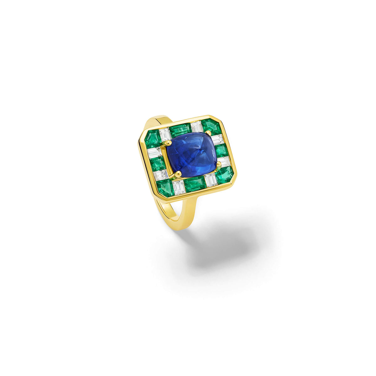Handcrafted 18ct yellow gold ring featuring a central sugarloaf blue sapphire from Madagascar surrounded by square cut emeralds and baguette cut diamonds.