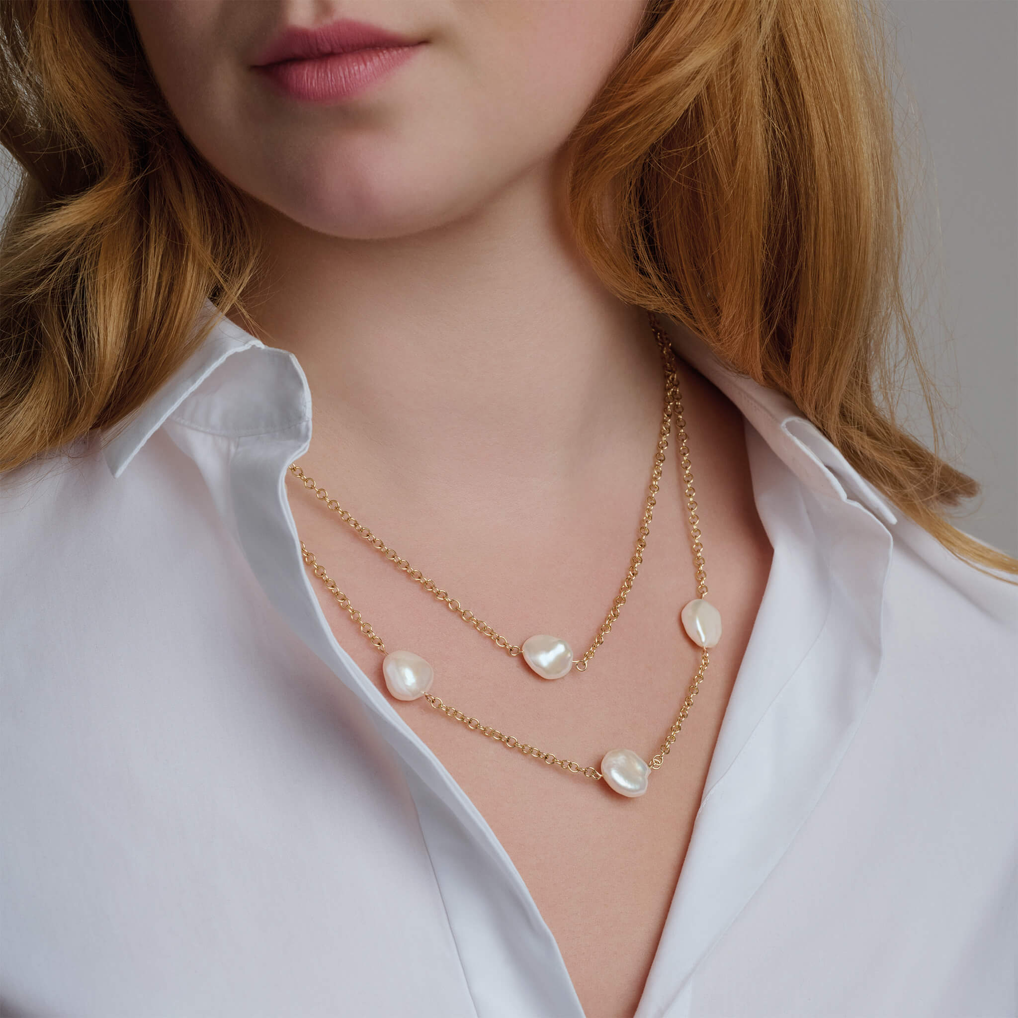 Handcrafted gold necklace featuring six baroque pearls on a gold chain.