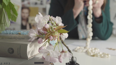 Video of Cassandra Goad examining a selection of jewels in various metals, set with precious stones.