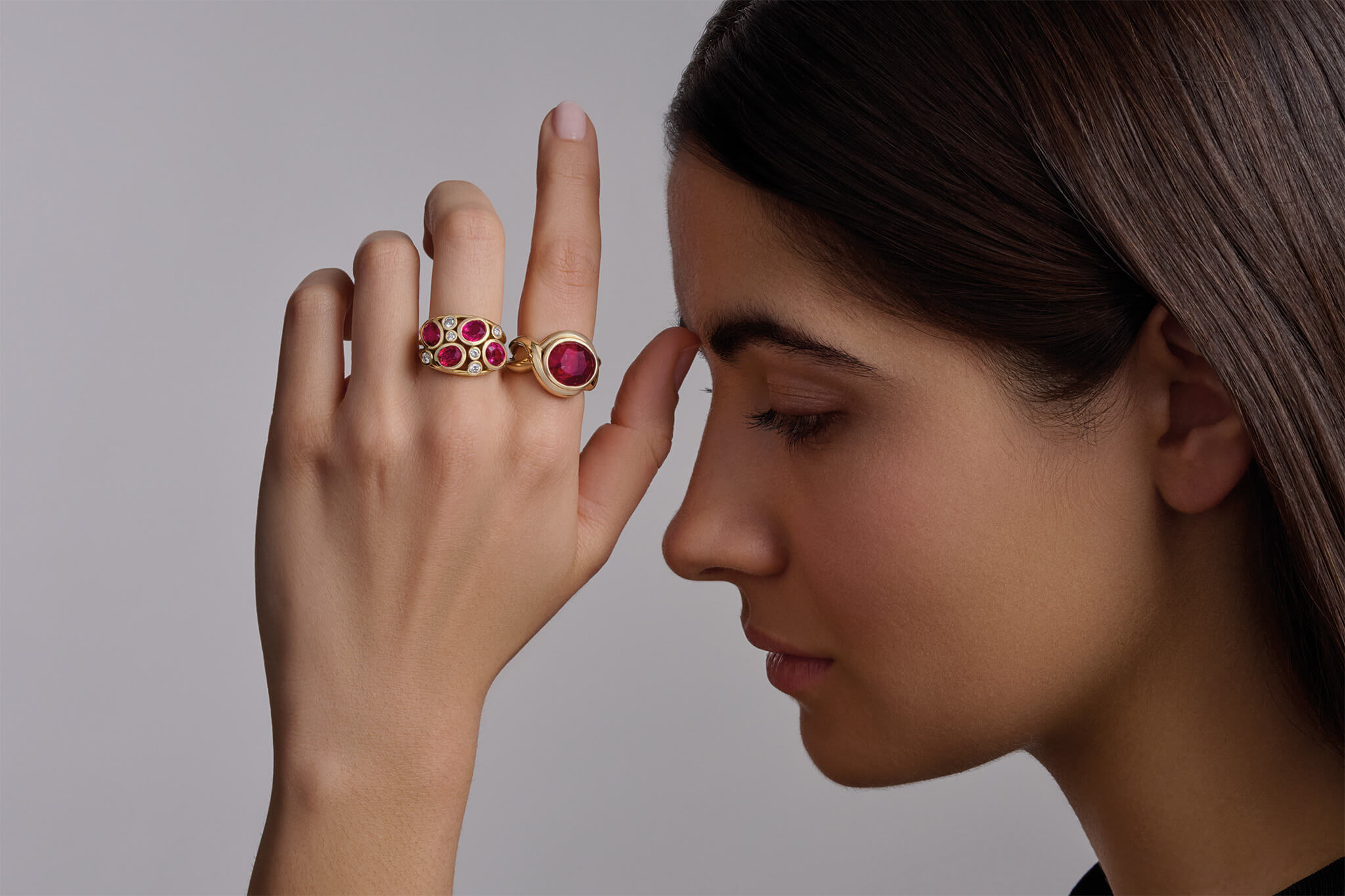 Model wearing Aeneus and Severine rings with ruby gemstone, the birthstone of July.