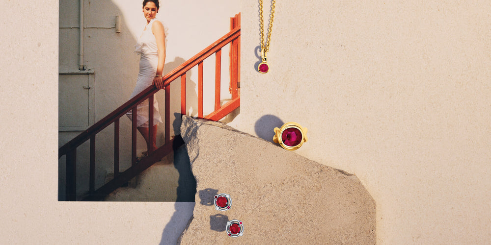 Cassandra Goad ruby jewellery still life with a rock and a postcard