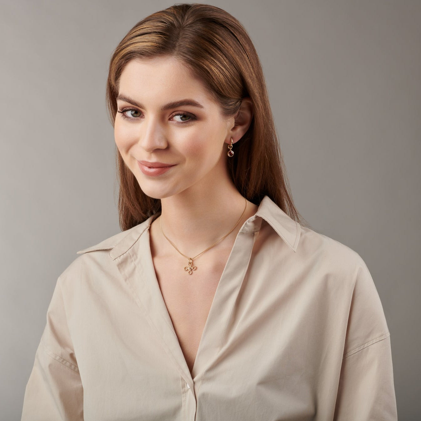 Model wearing a handcrafted 9ct yellow gold necklace pendant featuring a textured rope-like shape with a diamond.
