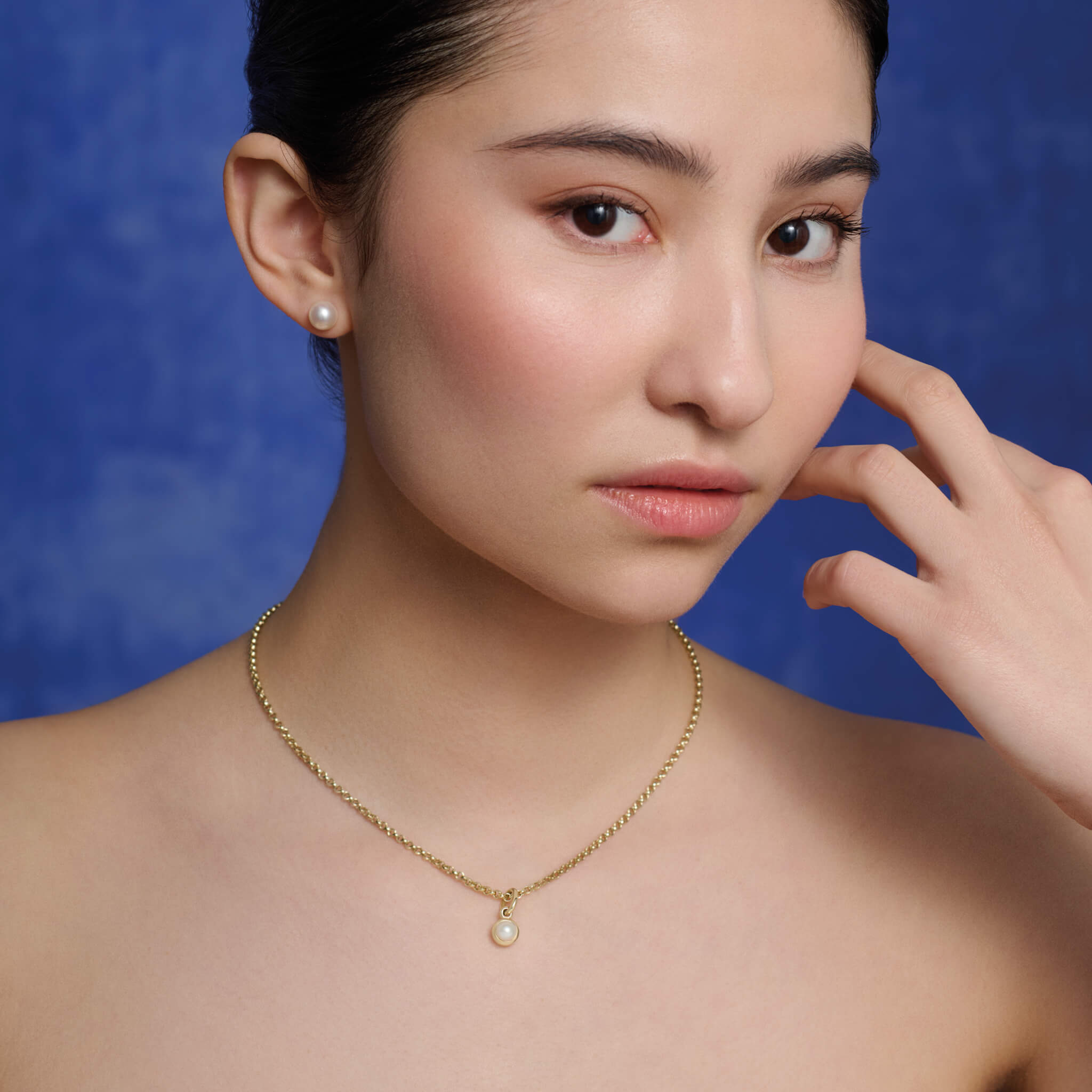 Model wears Cassandra Goad yellow gold Talya necklace pendant in pearl.