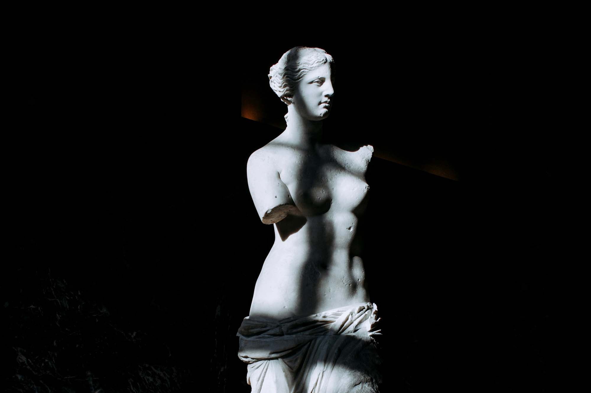 Bust of the Venus of Milo sculpture on the Louvre museum with sun and shadow effect.