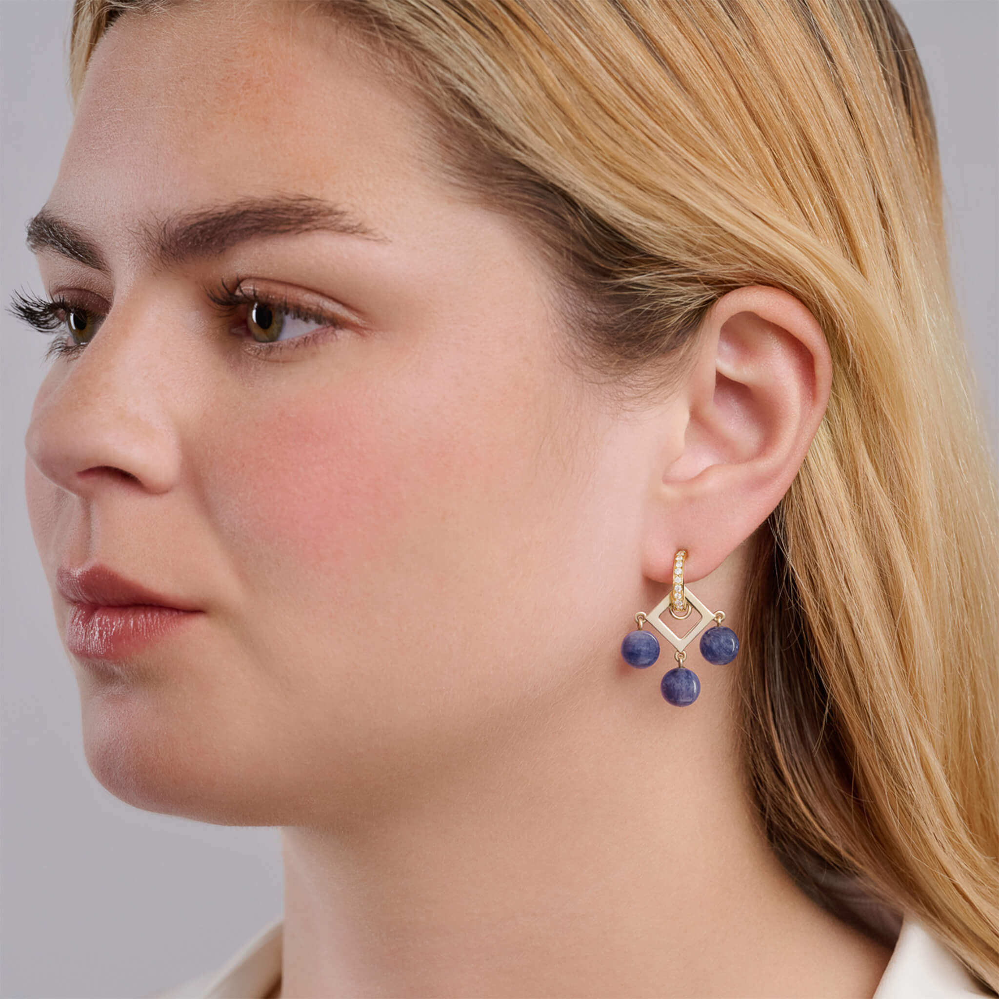 Handcrafted 9ct yellow gold earring drops with a central geometric shape and three blue tanzanite beads.
