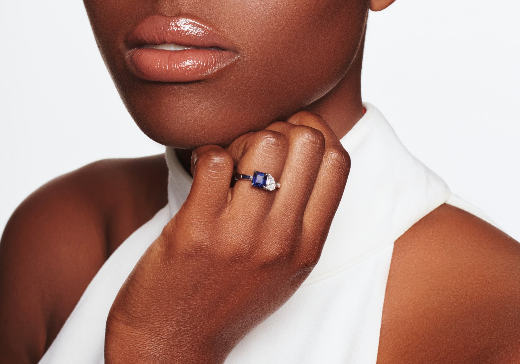 Model wearing a handcrafted Toi et Moi ring with blue sapphire and diamond with an 18ct white gold band.