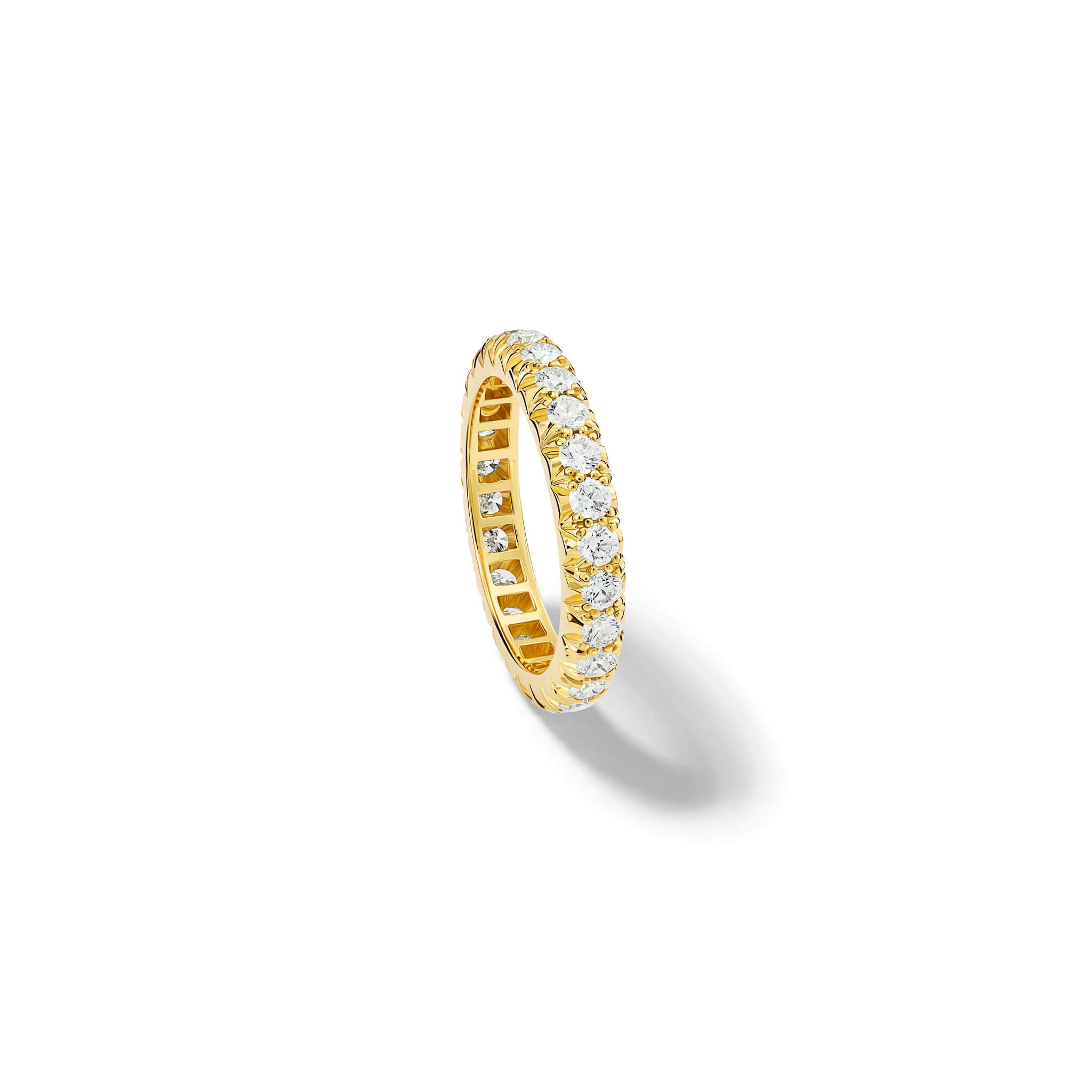 Handcrafted 18ct yellow gold eternity ring with diamonds set in a claw setting photographed from the side.